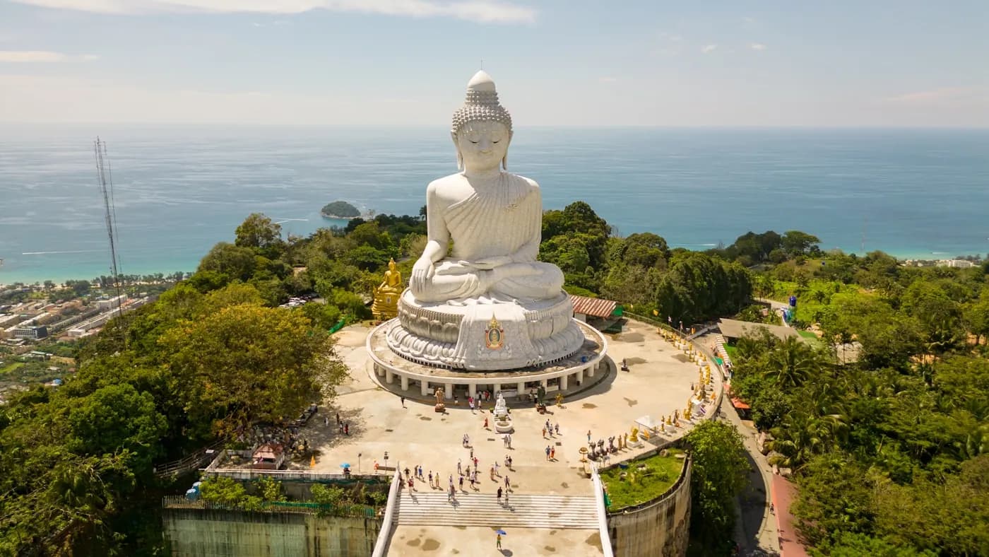 The white marble Big Buddha on its terrace above the coast, with visitors below