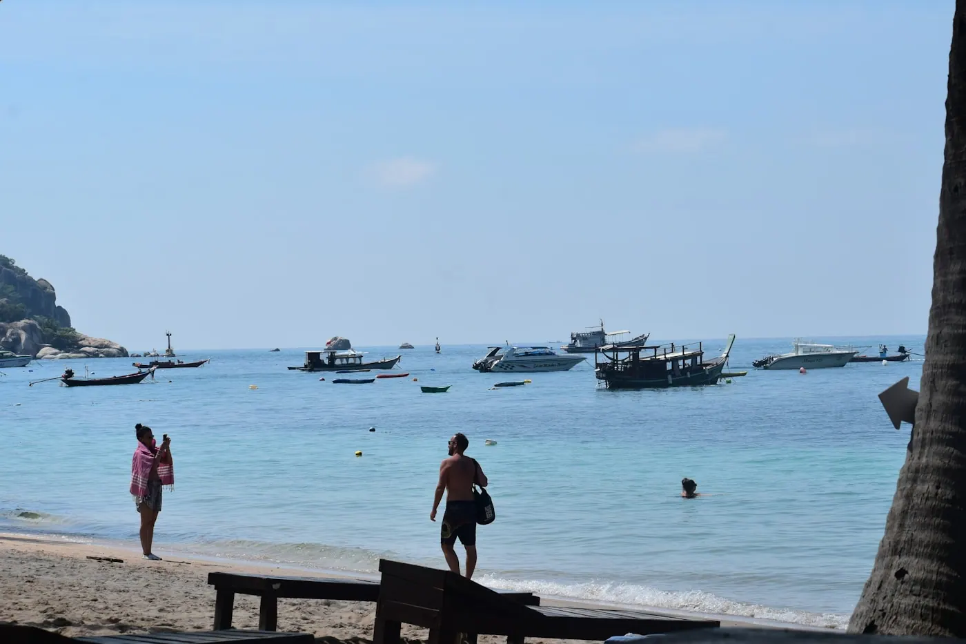 Visitors taking photographs from a jetty above moored boats