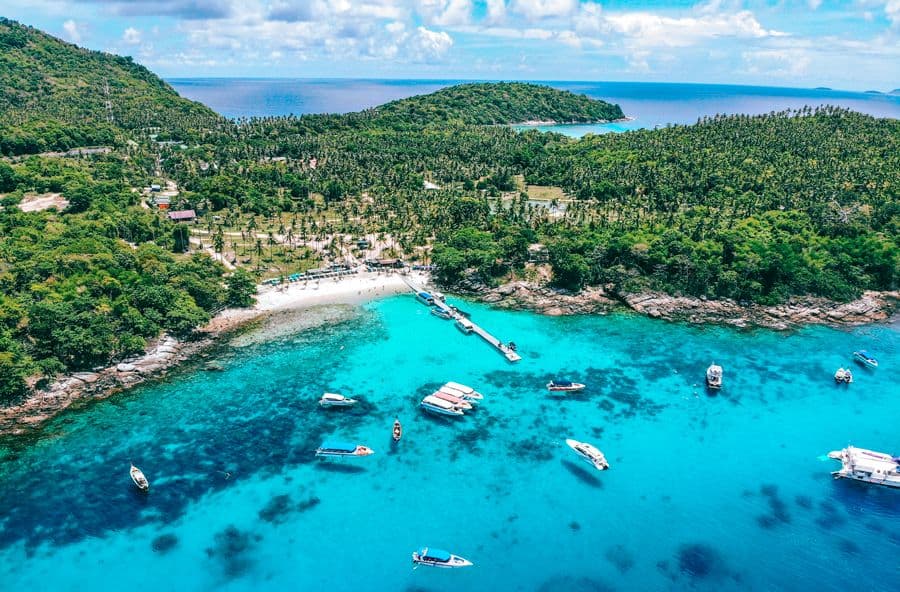 Boats anchored over clear water in a bay at Racha Yai